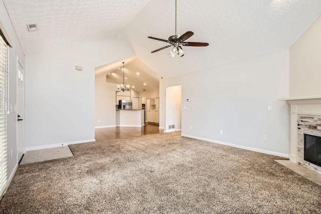 unfurnished living room featuring carpet, a fireplace, vaulted ceiling, and a textured ceiling