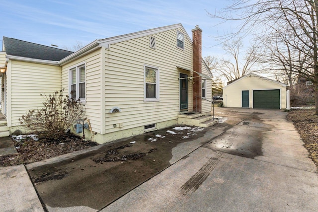 view of home's exterior featuring an outbuilding, a detached garage, and a chimney