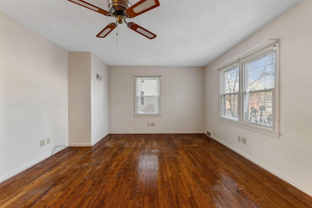 spare room with visible vents, dark wood finished floors, baseboards, and ceiling fan