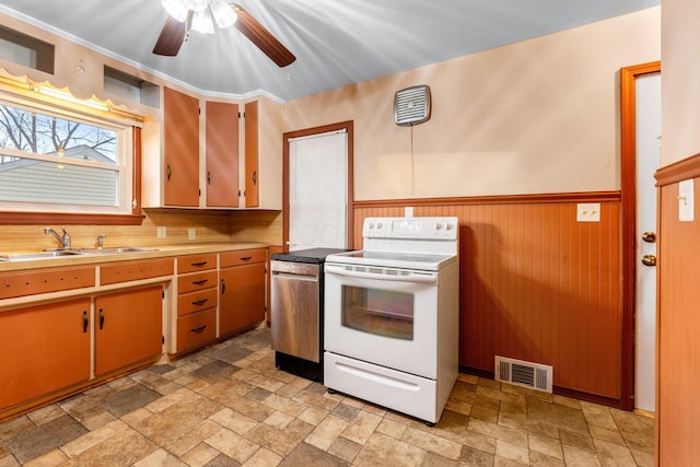 kitchen with white electric range oven, light countertops, visible vents, stone finish floor, and a sink