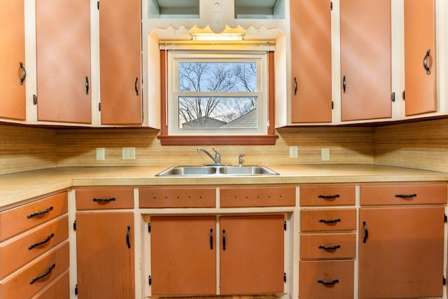 kitchen with light countertops, a sink, and decorative backsplash