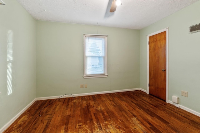 unfurnished room with ceiling fan, a textured ceiling, baseboards, and dark wood-style flooring