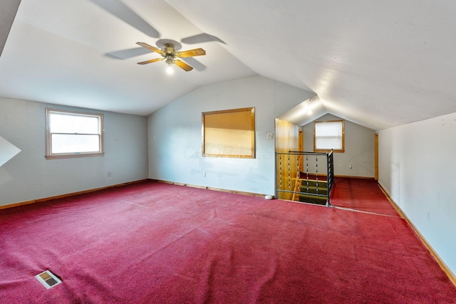 bonus room featuring lofted ceiling, carpet floors, visible vents, and baseboards