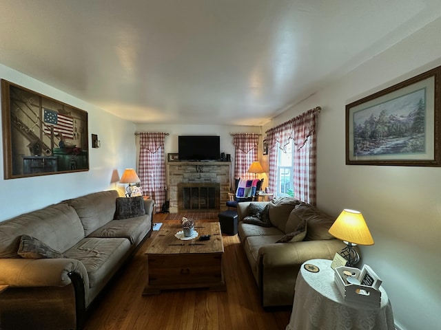 living area featuring a stone fireplace and wood finished floors