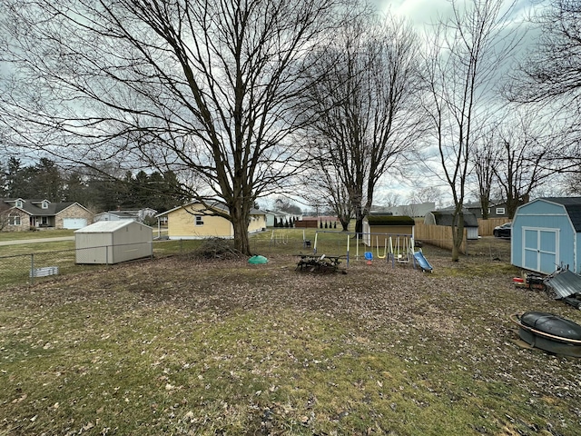 view of yard featuring a storage unit, a playground, and an outdoor structure