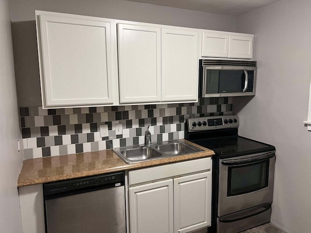 kitchen featuring a sink, tasteful backsplash, appliances with stainless steel finishes, and white cabinets