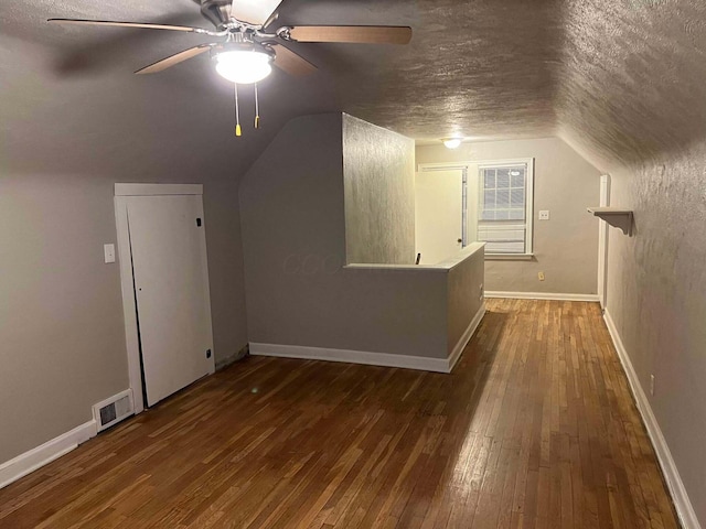 additional living space featuring hardwood / wood-style flooring, visible vents, and lofted ceiling