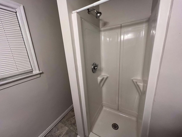 bathroom with baseboards and walk in shower