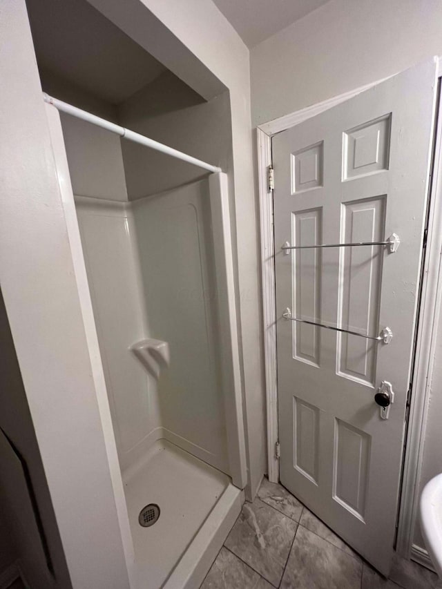 full bathroom with a shower stall and marble finish floor