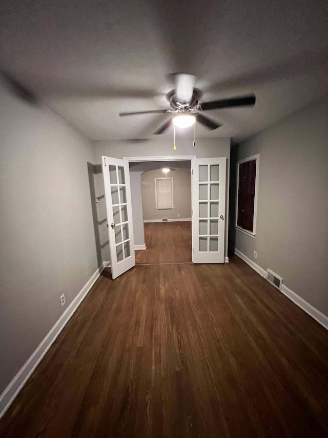 empty room with visible vents, ceiling fan, baseboards, french doors, and wood finished floors