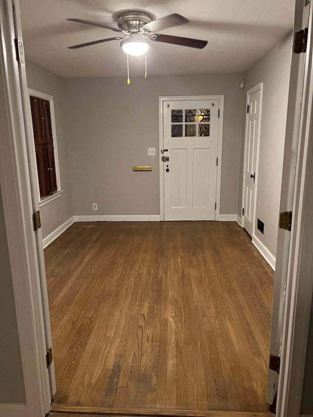 entryway with dark wood finished floors, baseboards, and ceiling fan