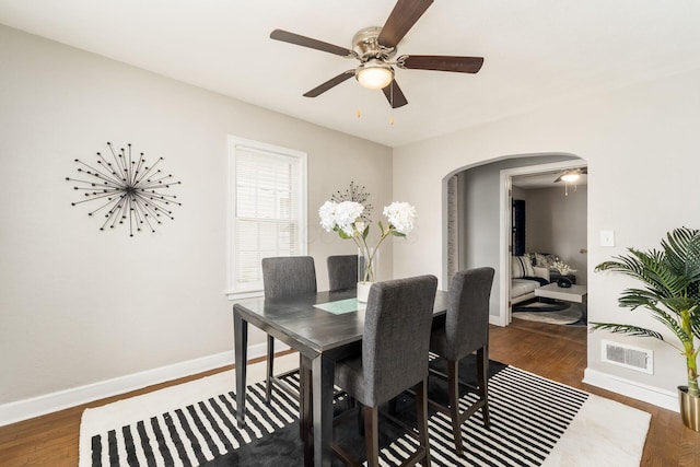 1724 E Livingston Ave, Columbus, OH 43205 - dining room featuring arched walkways, baseboards, ceiling fan, and wood finished floors