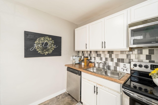 1724 E Livingston Ave, Columbus, OH 43205 - kitchen with stainless steel appliances, a sink, tasteful backsplash, baseboards, and white cabinetry