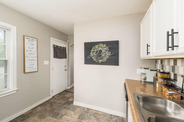 1724 E Livingston Ave, Columbus, OH 43205 - kitchen featuring a sink, baseboards, stone finish flooring, and white cabinets