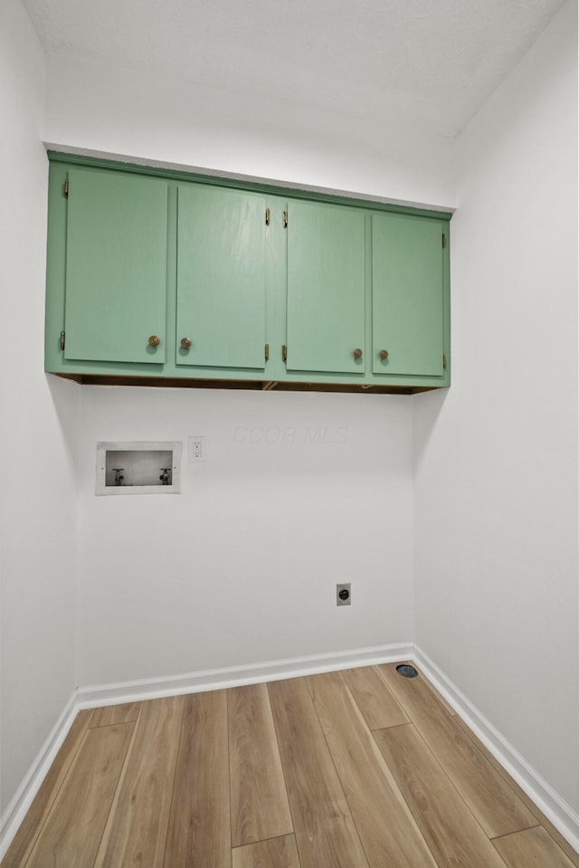 laundry room with cabinet space, baseboards, light wood-style flooring, hookup for a washing machine, and electric dryer hookup