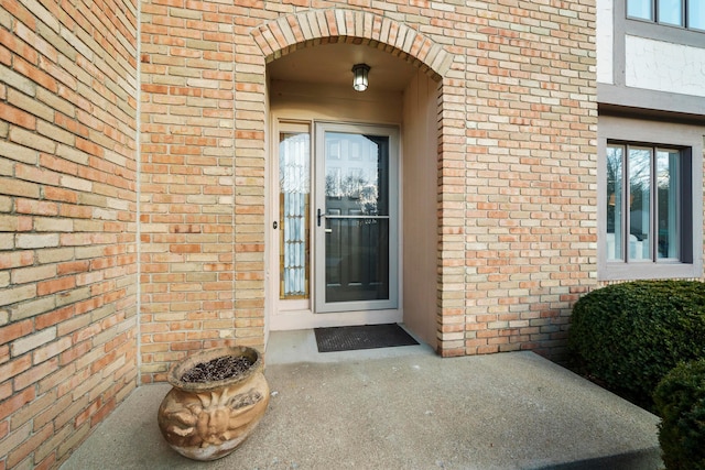 view of exterior entry with brick siding