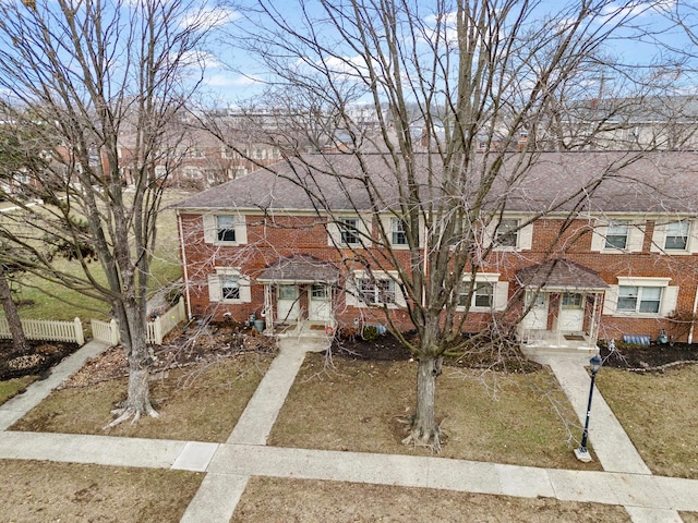 view of property with fence and brick siding