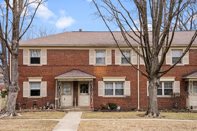 townhome / multi-family property with brick siding and a shingled roof