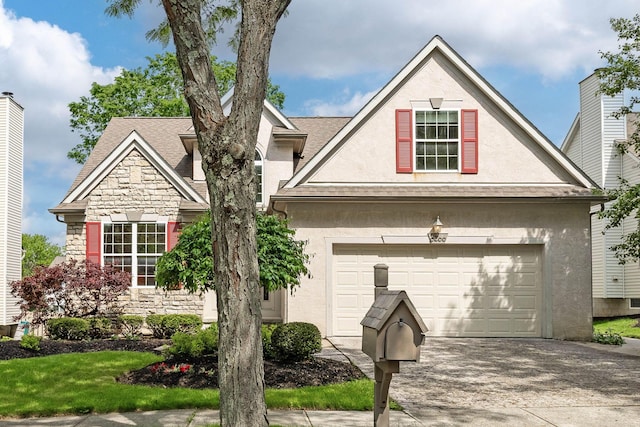 6266 Misty Cove Ln, Columbus, OH 43231 - view of front of house with stucco siding, driveway, stone siding, and roof with shingles