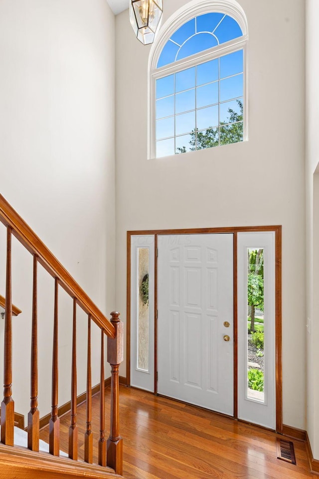 6266 Misty Cove Ln, Columbus, OH 43231 - foyer entrance featuring a high ceiling, stairway, wood finished floors, and a chandelier