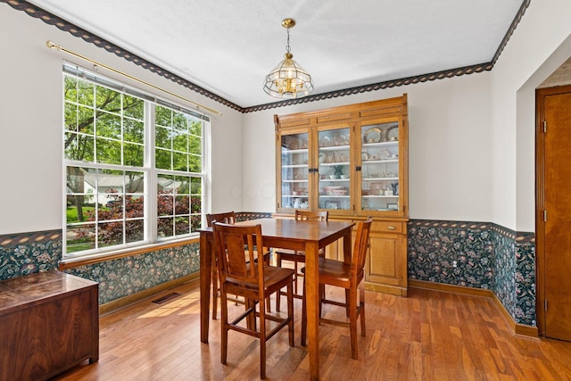 6266 Misty Cove Ln, Columbus, OH 43231 - dining room featuring a chandelier, a wainscoted wall, light wood-style floors, wallpapered walls, and crown molding