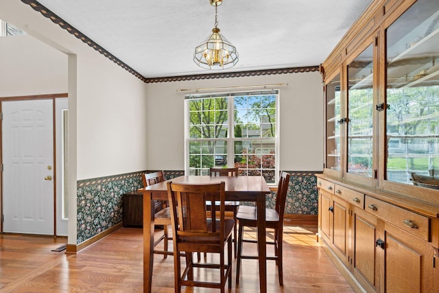 6266 Misty Cove Ln, Columbus, OH 43231 - dining room featuring baseboards, crown molding, light wood-type flooring, a chandelier, and a textured ceiling