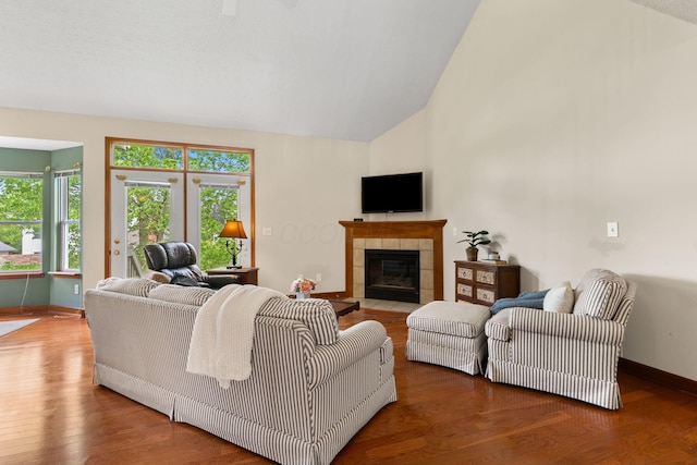 6266 Misty Cove Ln, Columbus, OH 43231 - living area featuring a tiled fireplace, baseboards, wood finished floors, and high vaulted ceiling
