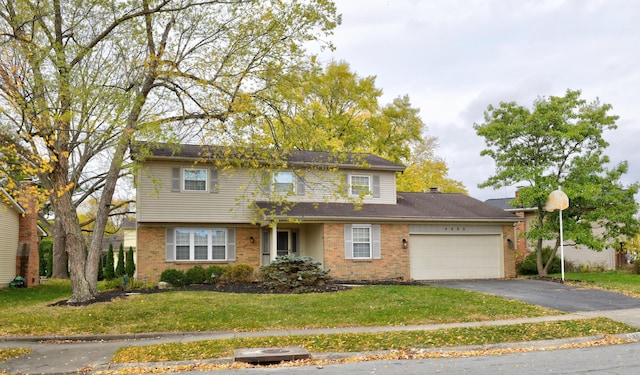 traditional-style house with a garage, a front lawn, aphalt driveway, and brick siding