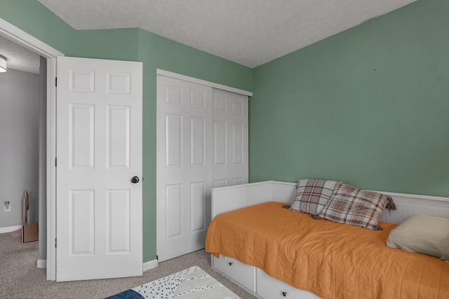 bedroom featuring a textured ceiling, a closet, and carpet