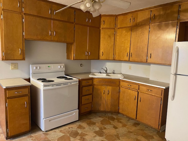 kitchen featuring light countertops, white appliances, brown cabinetry, and a sink