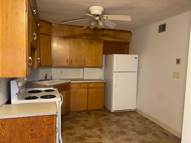 kitchen featuring white appliances, visible vents, brown cabinets, light countertops, and a sink