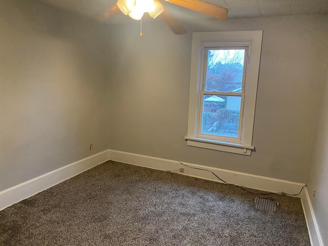 carpeted spare room with a ceiling fan, visible vents, and baseboards