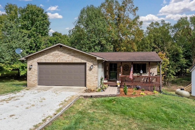 single story home featuring brick siding, gravel driveway, a front yard, covered porch, and an attached garage