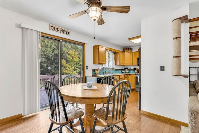 dining room with a ceiling fan, light wood-style floors, and baseboards