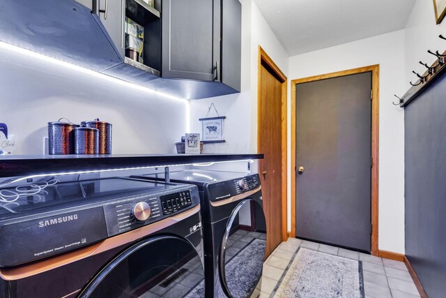 laundry room featuring separate washer and dryer, light tile patterned flooring, cabinet space, and baseboards