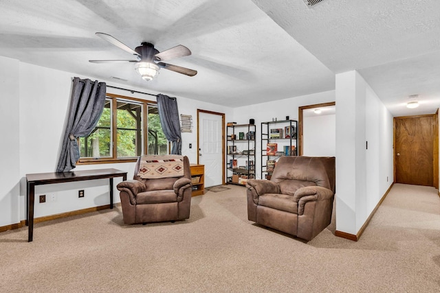 sitting room featuring a ceiling fan, baseboards, a textured ceiling, and carpet flooring