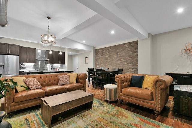 living room featuring a notable chandelier, recessed lighting, brick wall, wood finished floors, and beamed ceiling