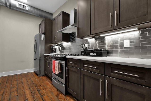 kitchen featuring visible vents, decorative backsplash, appliances with stainless steel finishes, light countertops, and wall chimney range hood