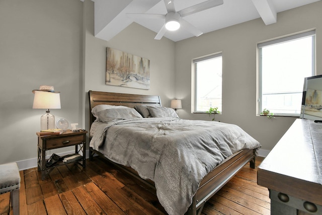 bedroom featuring beam ceiling, dark wood finished floors, baseboards, and ceiling fan