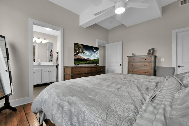 bedroom with dark wood-type flooring, a ceiling fan, visible vents, baseboards, and ensuite bath