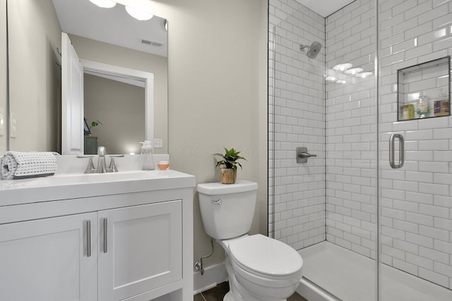 bathroom featuring toilet, vanity, a shower stall, and visible vents