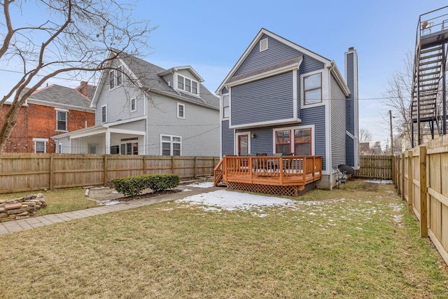 rear view of property featuring a yard, a fenced backyard, a chimney, and a wooden deck