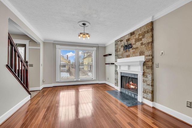 unfurnished living room featuring baseboards, wood finished floors, and crown molding