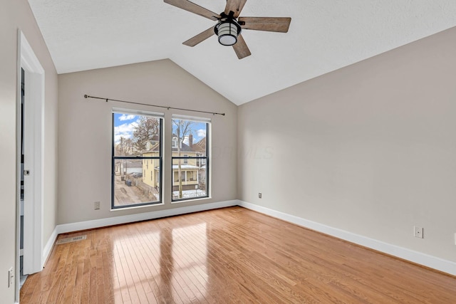 interior space featuring lofted ceiling, light wood-style flooring, and baseboards