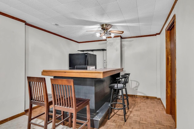 bar featuring freestanding refrigerator, visible vents, crown molding, and a dry bar