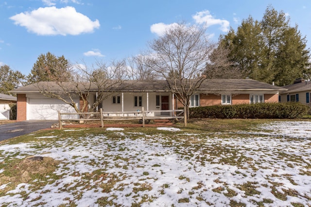 ranch-style home with a garage, brick siding, and driveway