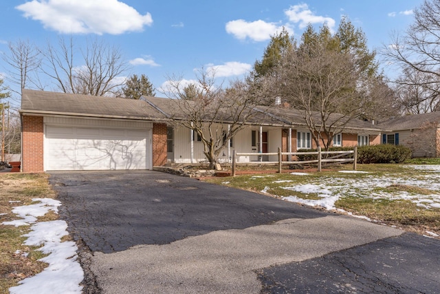 ranch-style home with driveway, a garage, fence, and brick siding