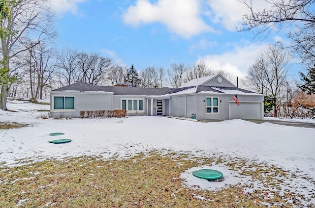 snow covered house with an attached garage