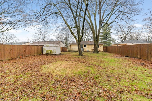 view of yard with a fenced backyard, an outdoor structure, and a shed