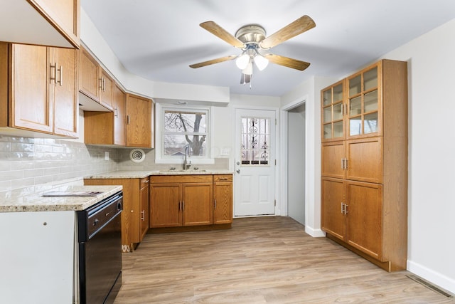 kitchen with light wood-style flooring, glass insert cabinets, brown cabinetry, and backsplash